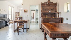 A room with a piano, a wooden table, and a large wooden cabinet. - La Terrazza in Centro, Genova (Genoa)