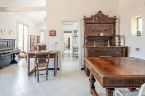 A room with a piano, a wooden table, and a large wooden cabinet. - La Terrazza in Centro, Genova (Genoa)
