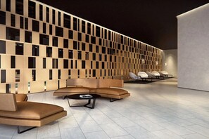 Ein modernes Interieur mit einer Sitzecke, einer Wand mit geometrischem Muster und einem pflegeleichten, gefliesten Boden.