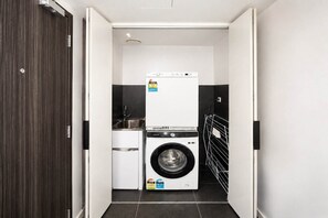 Ein kleiner Hauswirtschaftsraum mit Waschmaschine, Trockner und Spüle.