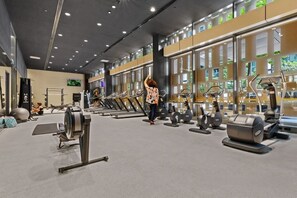 Ein modernes Fitnessstudio mit Laufbändern, Crosstrainern und Kurzhanteln.