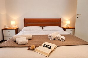 A neatly made bed with white linens, two bedside lamps, a bedside telephone, and a book with glasses on the bed. - Villa in Donnalucata with 4 bedrooms sleeps 10 (Donnalucata)