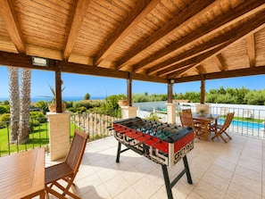 Eine Außenpatio mit Kicker, Sitzgelegenheiten und Blick auf den Ozean.