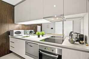 Eine moderne Küche mit Backofen, Mikrowelle und Dunstabzugshaube.