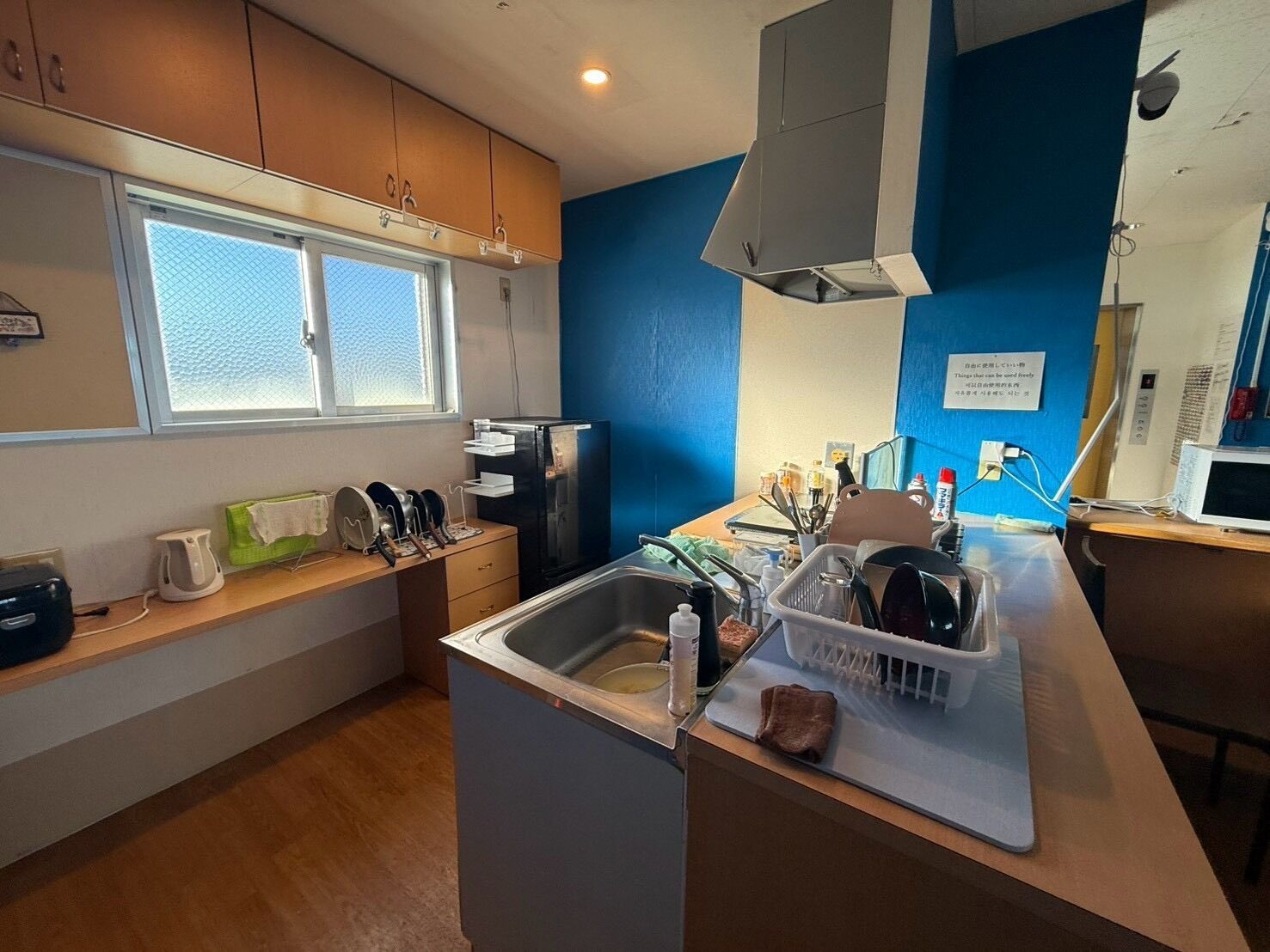 A compact kitchen with a sink, a microwave, and a window.