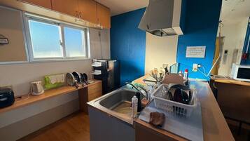 A compact kitchen with a sink, a microwave, and a window.