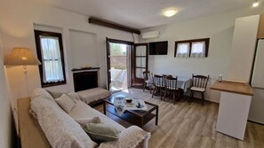 A living room with a sofa, coffee table, and dining area with chairs and a table. - Halikidiki, Family house to enjoy by the beach (Kalives Polygyrou)