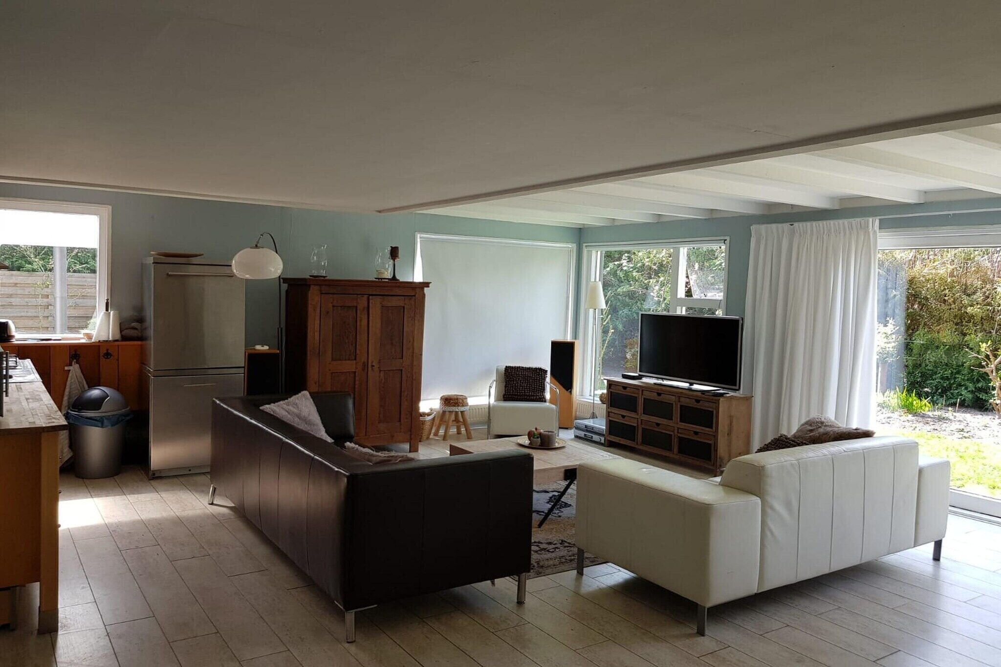 Un espacio habitable amplio con un sofá, un televisor y un armario.