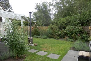 Un pati amb gespa, una tanca de fusta i diferents plantes.