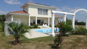 A two-story house with a swimming pool, white columns, and a covered patio area. - Unique house with an interior garden and a view of the Pyrenees mountain range (Toujouse)