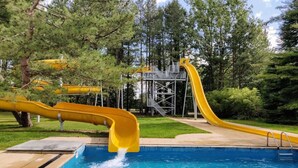 En swimmingpool med to gule rutsjebaner.