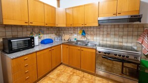 A kitchen with wooden cabinets, a microwave, a stove, and a sink.
