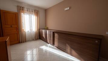 A room with a wooden door, a cabinet, and a tiled floor.