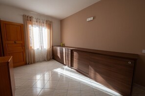 A room with a wooden door, a cabinet, and a tiled floor.