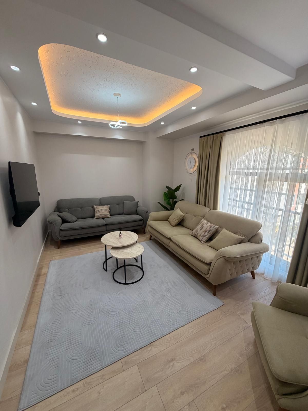 A modern living room with a grey sofa, a beige sofa, and a coffee table.