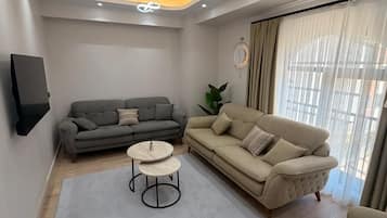 A modern living room with a grey sofa, a beige sofa, and a coffee table.