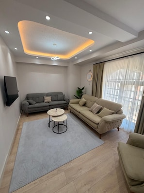 Una sala de estar moderna con un sofá gris, un sofá beige y una mesa de centro.