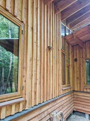 A wooden cabin with large windows and a sloped roof.