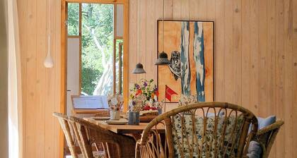 Hand-built timber and clay cottage by Bøtøskoven