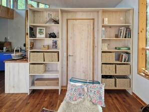 A room with wooden shelving units containing books, baskets, and decorative items.