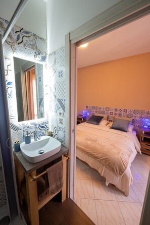 A bedroom with a bed, a bedside table, and a nightstand.