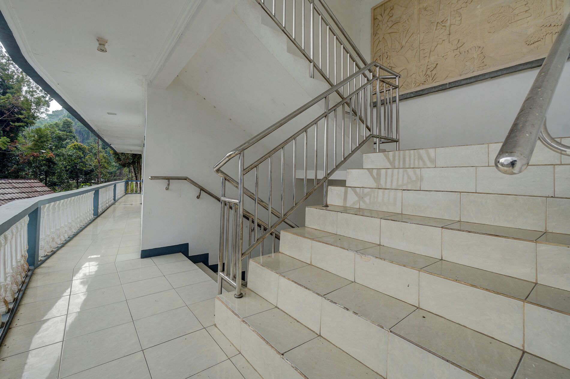 A staircase with metal railings and beige tiles.