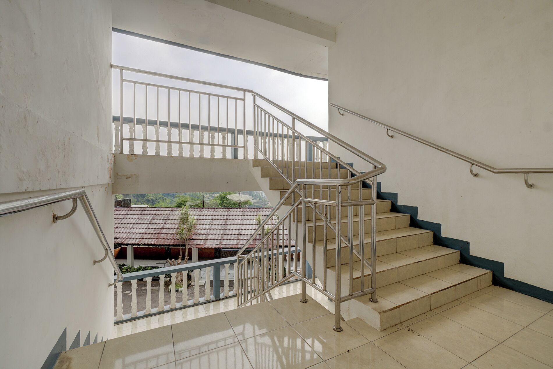 A staircase with metal railings and beige steps leading to an upper level.