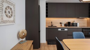 A modern kitchen with dark cabinetry, a built-in microwave, and a coffee maker. - Acropolis Executive Residence  | Chatzichristou Str.16.Athens 11742, Bill & John Apartments & Villas (Athens)