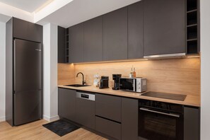 A modern kitchen with a built-in dishwasher, a coffee maker, and a microwave. - Acropolis Executive Residence  | Chatzichristou Str.16.Athens 11742, Bill & John Apartments & Villas (Athens)
