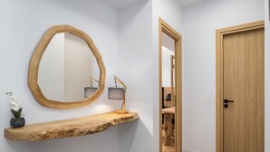 A hallway with a wooden bench, a mirror, and a door. - Acropolis Executive Residence  | Chatzichristou Str.16.Athens 11742, Bill & John Apartments & Villas (Athens)