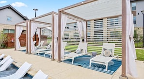 A poolside area with sun loungers and a covered seating area.