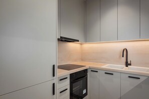A modern kitchen with a dishwasher, oven, and a sink with a faucet. - Glyfada Prime Signature Residence, Glyfada Prime Living (Glyfada)