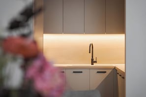 A modern kitchen with a sleek faucet, minimalistic cabinetry, and a neutral color palette. - Glyfada Prime Elegant Residence, Glyfada Prime Living (Glyfada)