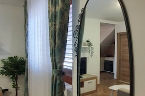 A room with a wooden floor, a white wall, a small white table, and a plant. - Comfort Accommodation Baošići Montenegro-One Bedroom Apartment with Terrace and Sea View (2) (Baosici)