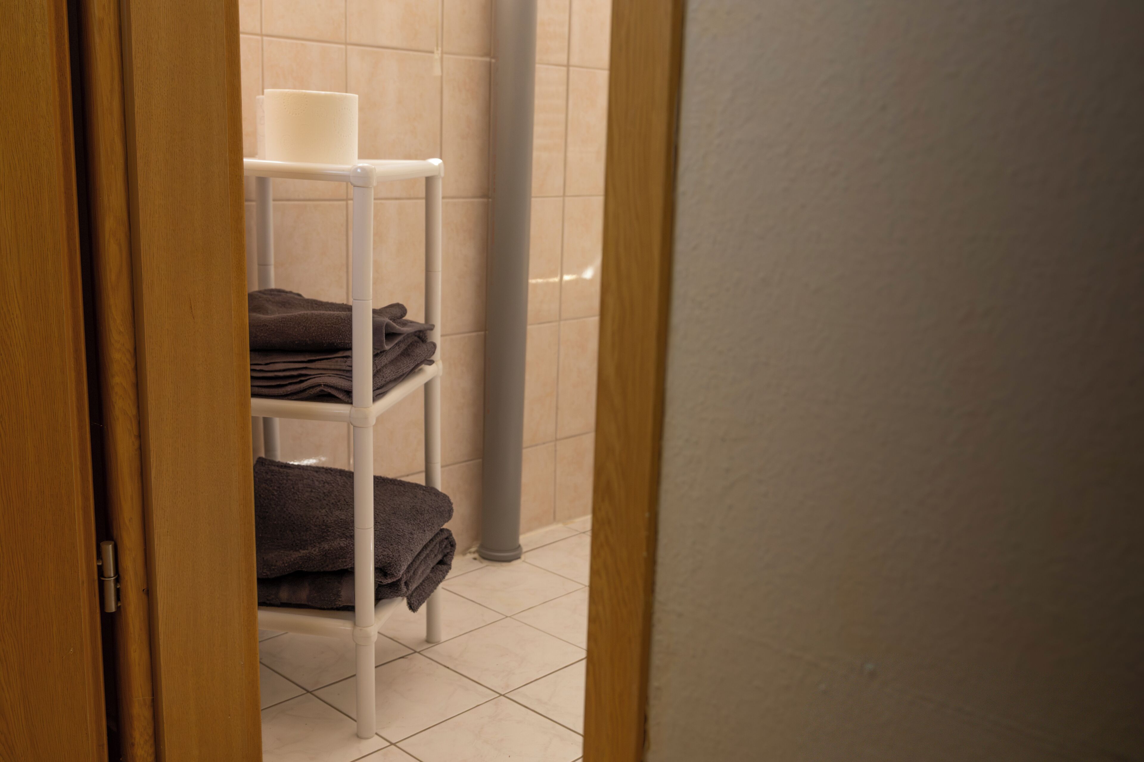 Ein Badezimmer mit einem weißen Handtuchhalter und gefalteten Handtüchern.