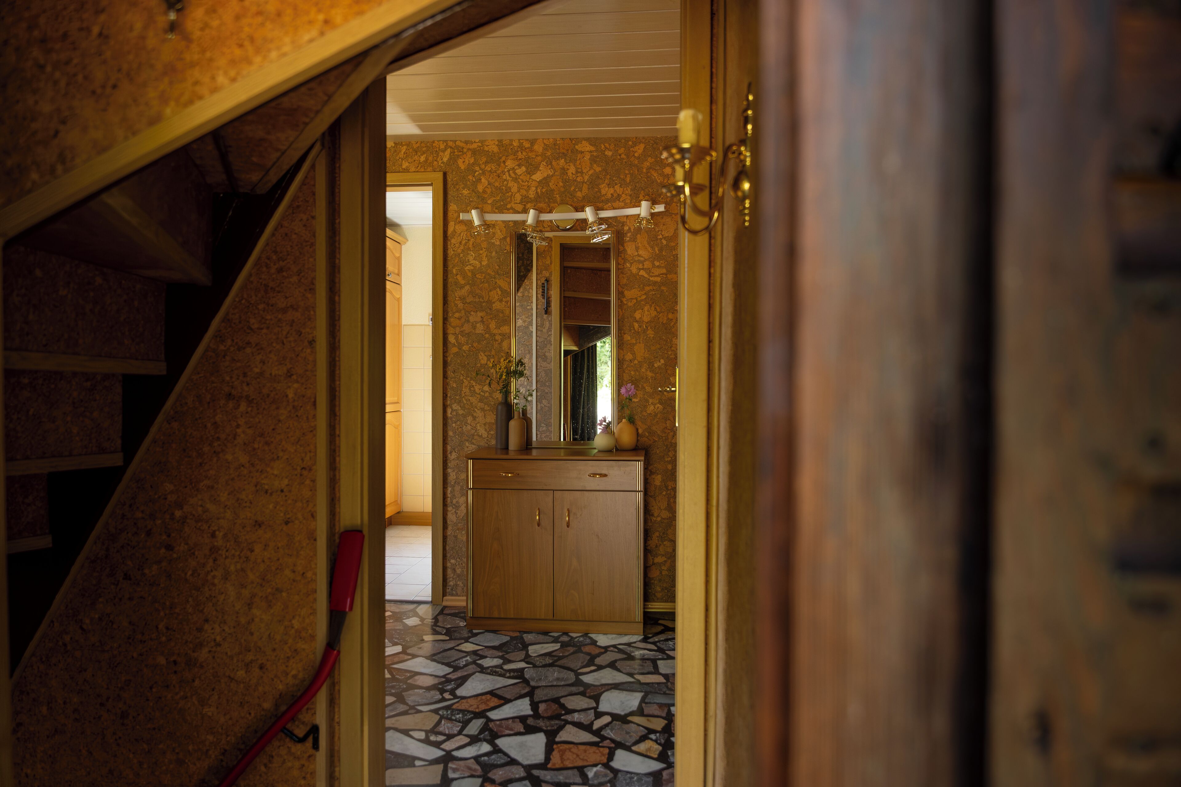 Une salle de bain avec un sol carrelé, un meuble-lavabo en bois et un miroir.