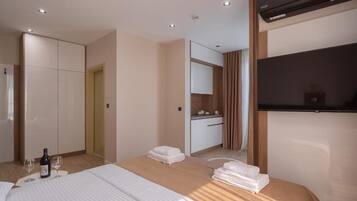 A hotel room with a bed, a minibar, a television, and a bathroom.