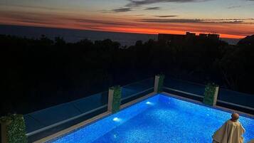 A swimming pool with a view of the sunset.