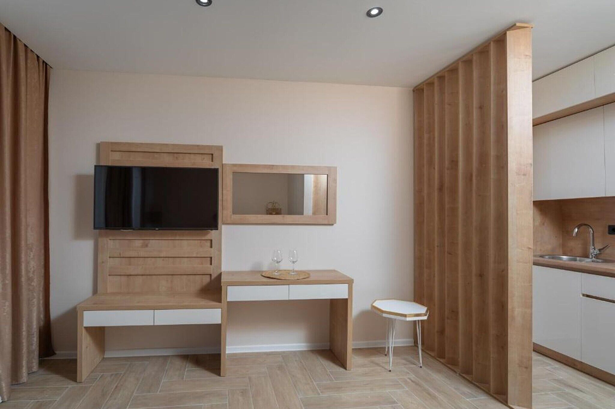 Una cocina moderna con armarios de madera, horno empotrado y una pequeña encimera blanca.