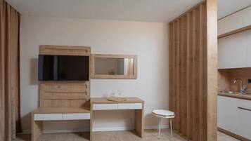 Una cocina moderna con armarios de madera, horno empotrado y una pequeña encimera blanca.