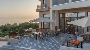 A rooftop terrace with outdoor seating and a view of the sea.