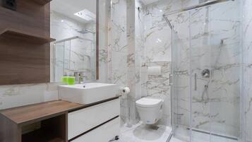 Ein modernes Badezimmer mit einer Marmerdusche, einem Holzbadezimmer-Waschtisch und einem Glaskabinenttoilette.