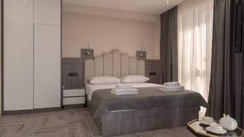 Een moderne slaapkamer met een bed, nachtkastjes, een kledingkast en een klein tafeltje met theeset.