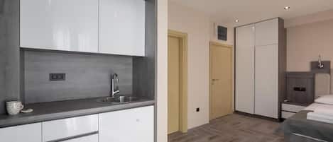 A modern kitchen with white cabinets, a stainless steel sink, and a countertop.