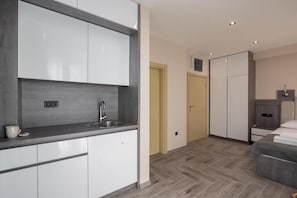 A modern kitchen with white cabinets, a stainless steel sink, and a countertop. - Hotel D'Iman - Classic Triple Room with Sea View and Balcony (402) (Dobra voda)