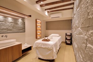 Un baño moderno con un espejo grande, un lavabo, un perchero para toallas y una cama con edredón blanco.