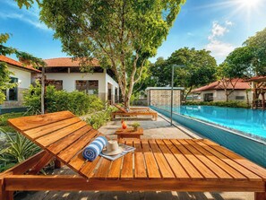 A poolside area with wooden loungers, a pool, and a building labeled 'AURORA'.