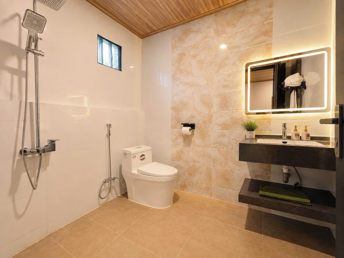 Une salle de bain moderne équipée d’une douche, de toilettes et d’un meuble-lavabo.
