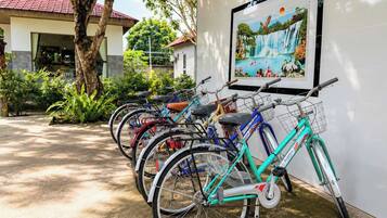 A row of bicycles parked against a wall with a framed picture above them.