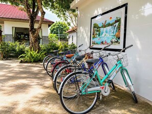 A row of bicycles parked against a wall with a framed picture above them.